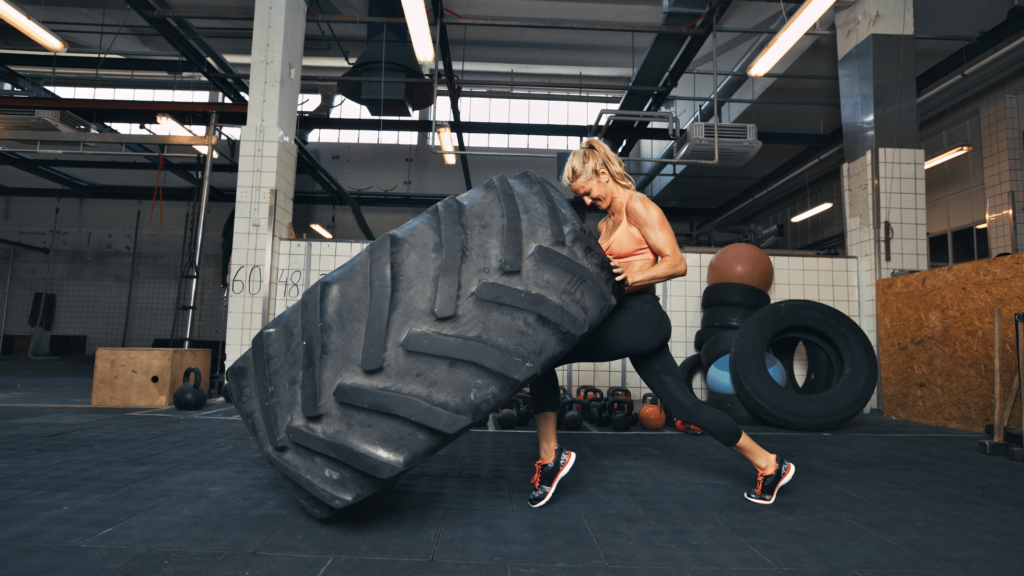 woman is exercising with tires